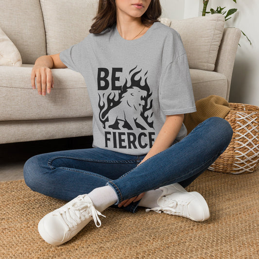 Person wearing a gray t-shirt with 'BE FIERCE' and a lion graphic, sitting on the floor in a living room.